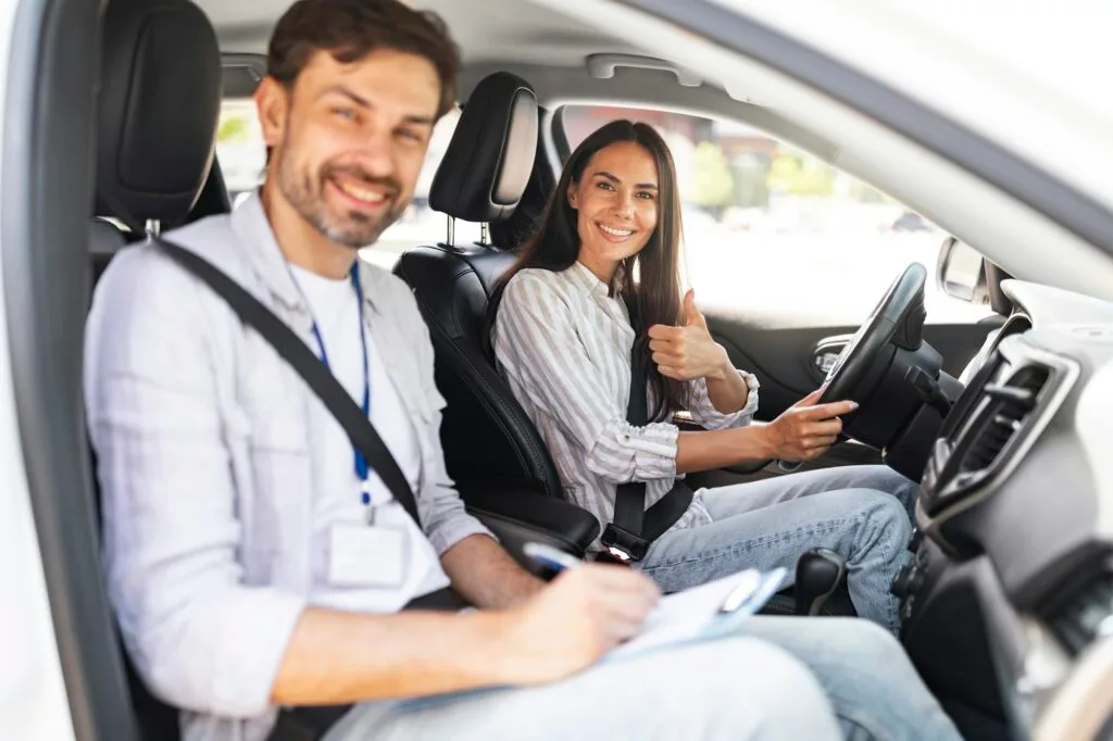 Femme Etudiant le jour de l'examen au volant avec un examinateur