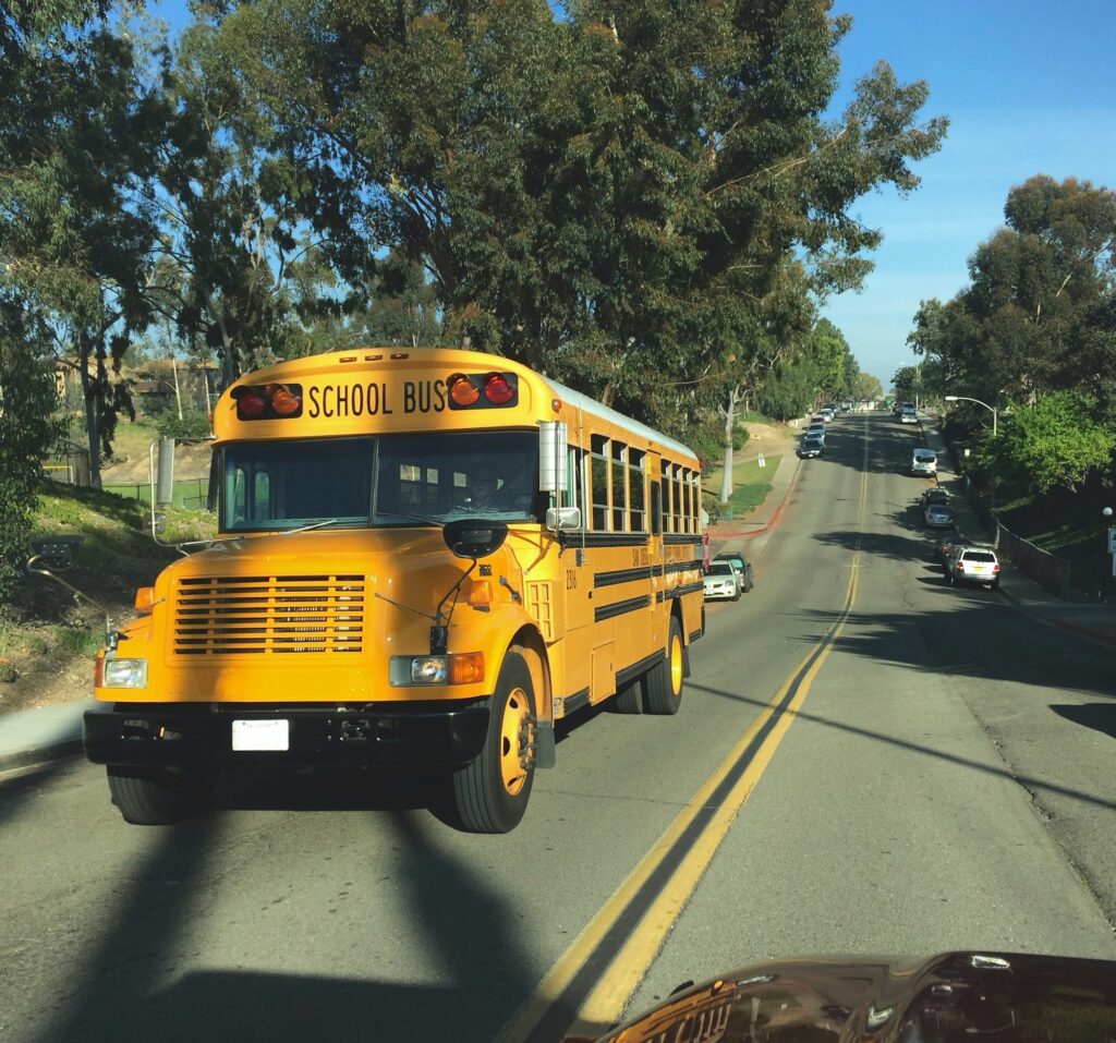 School bus driving on the street taking students to school